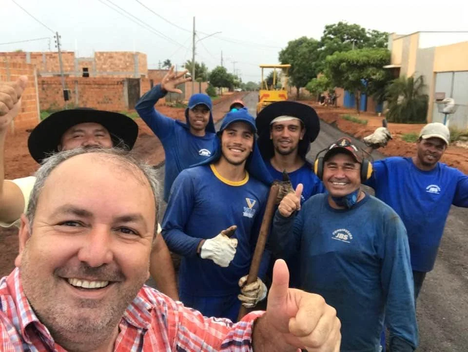 Alcino Barcelos junto a um grupo de pessoas em uma rua